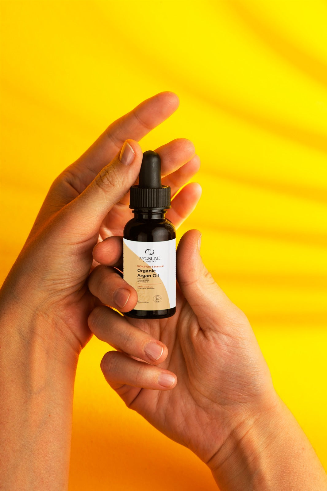Women holding with care argan oil tube