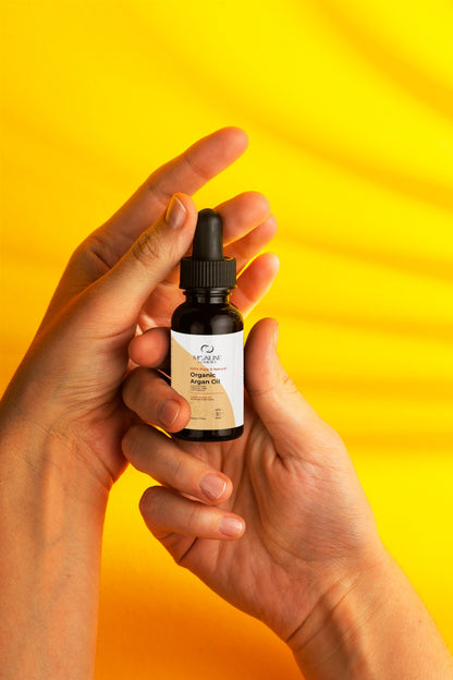 Women holding with care argan oil tube